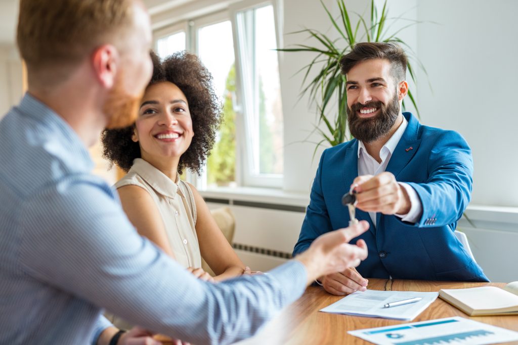 Estate agent giving keys to new homeowners.